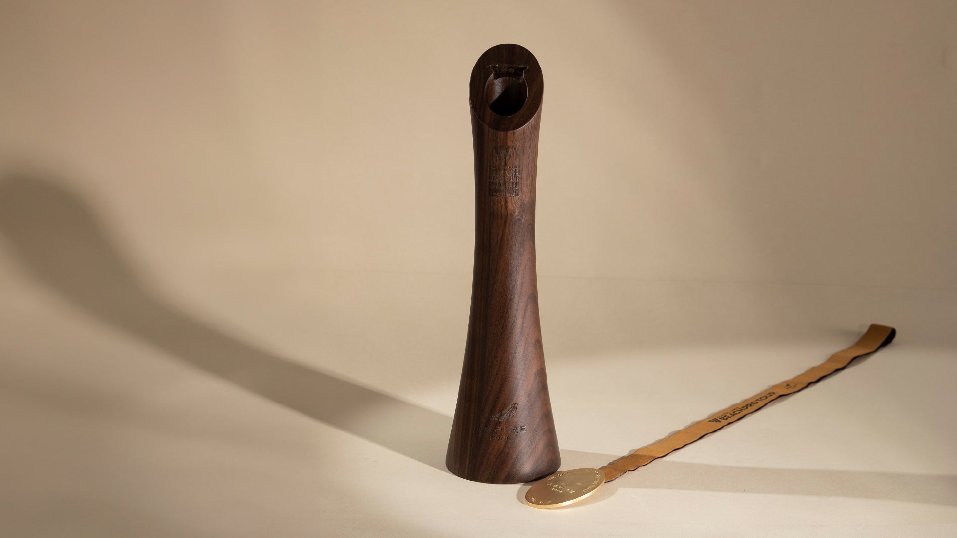 Overview of the design piece with the trophy standing tall and empty and the usually inside medal laid on the right side