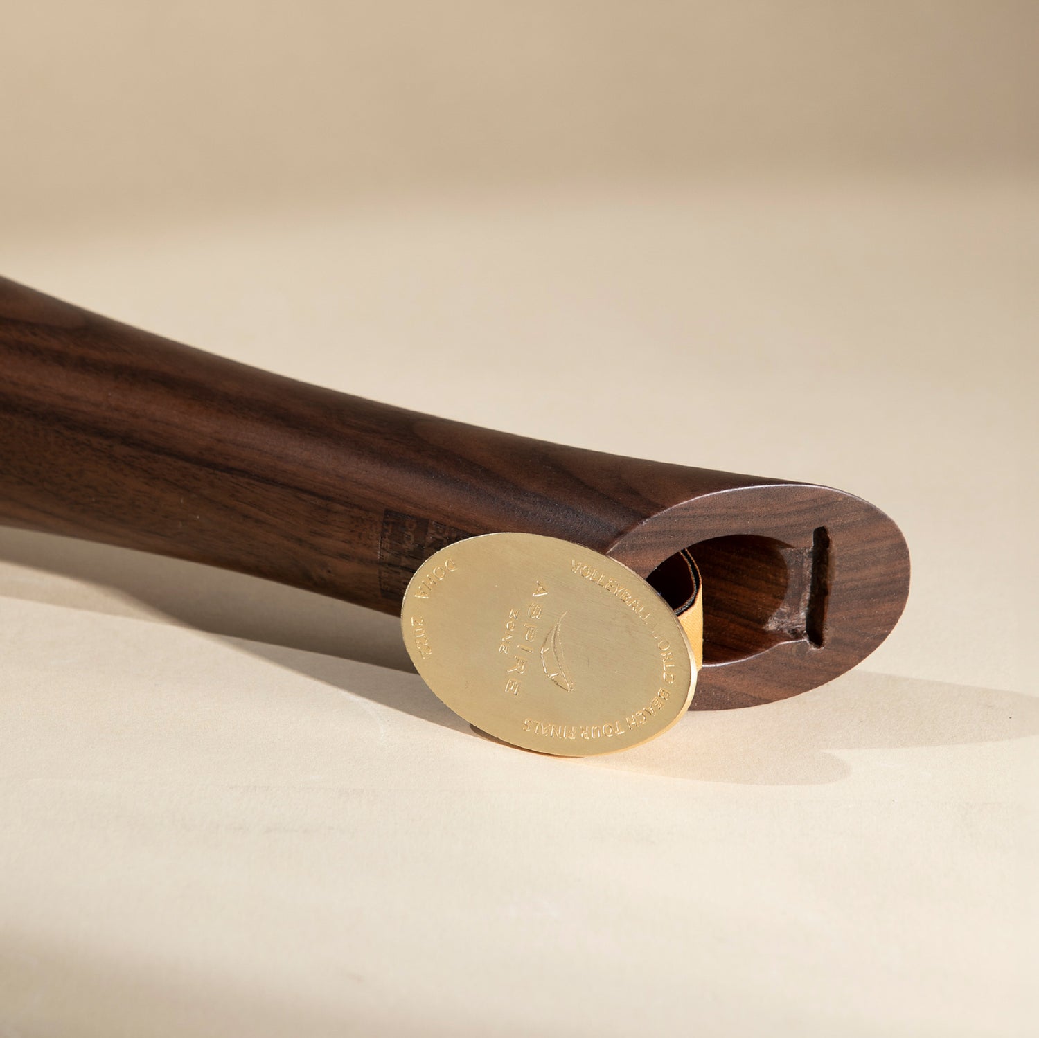 Wooden design piece laid horizontally with the golden metal sticking out from the top