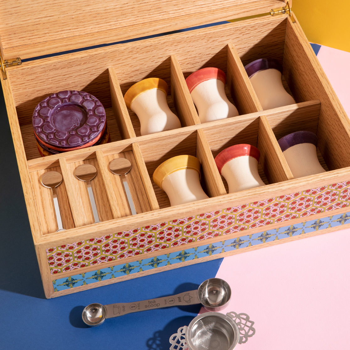 Topview of the opened container and all the elements separeted inside of it: cups, coaster and accessories