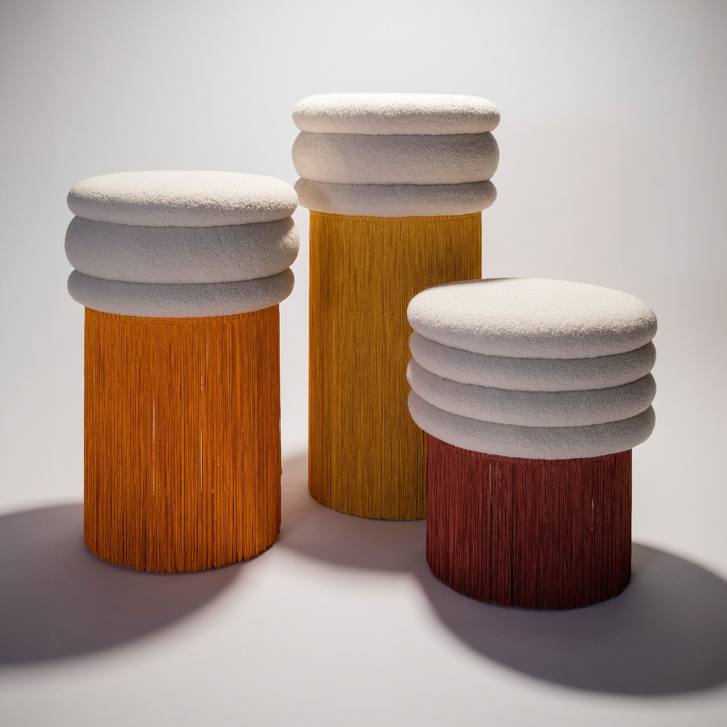 Three stool pieces from the Tessels Collection in warm colors and different heights