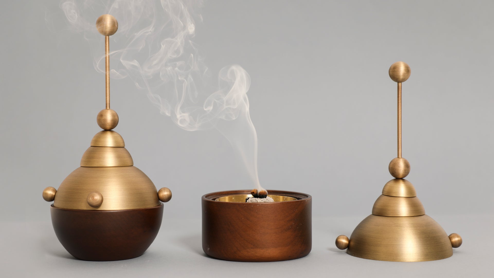 Front view of two incense burners, one closed and the other taken apart to see the smoke going against the other piece